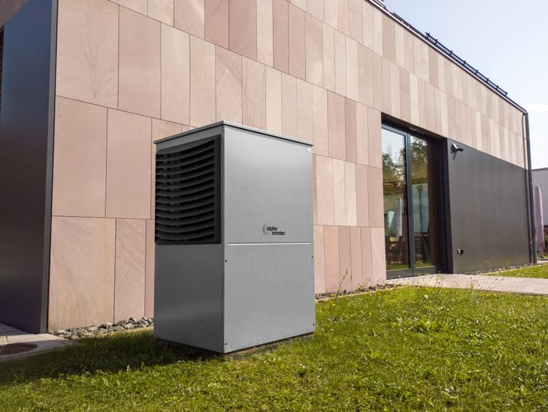 Air source heat pump unit beside a house